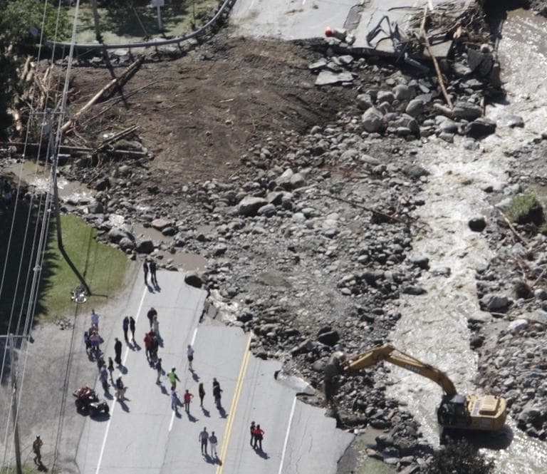 People gather alongside workers making repairs on Route 100 in Killington, Vt., Tuesday, washed out by flood waters from Tropical Storm Irene on Sunday. (AP)