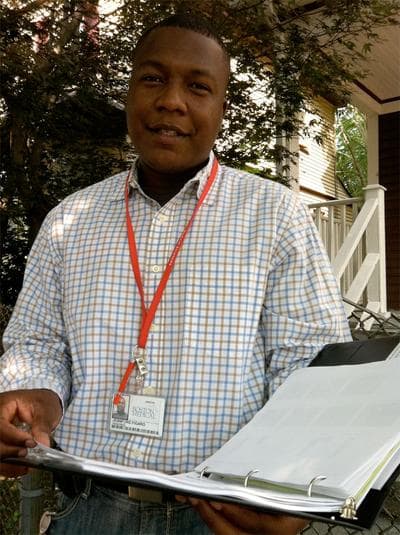 Jean Figaro reviews his notes before a home asthma care visit. (Martha Bebinger/WBUR)