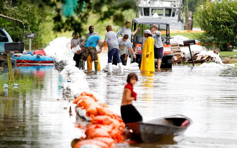 Parish crews placed sand bags along a flooded street in Lafitte, La., Sunday. (AP)