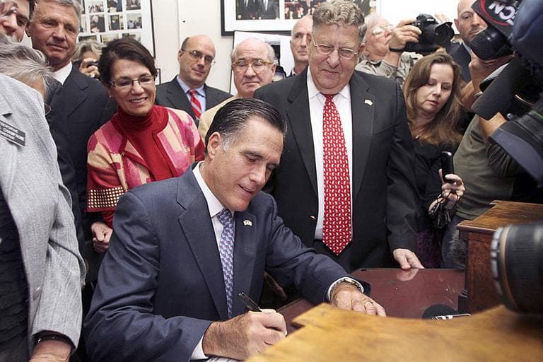 Former New Hampshire Gov. John Sununu, right, watches as Republican presidential candidate Mitt Romney fills out his candidacy papers to be on the New Hampshire ballot. (AP Photo/Jim Cole)