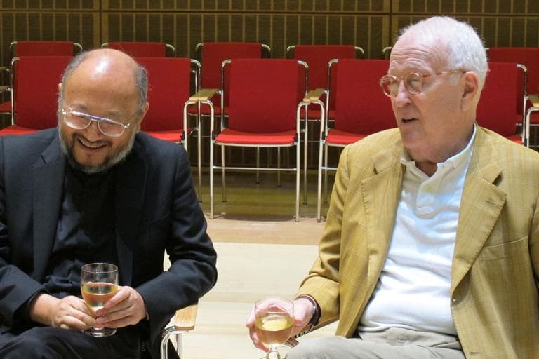 Acoustician Yasu Toyota, left and museum music director, Scott Nickrenz, share a celebratory drink after the completion of the five-year project. (Andrea Shea/WBUR)