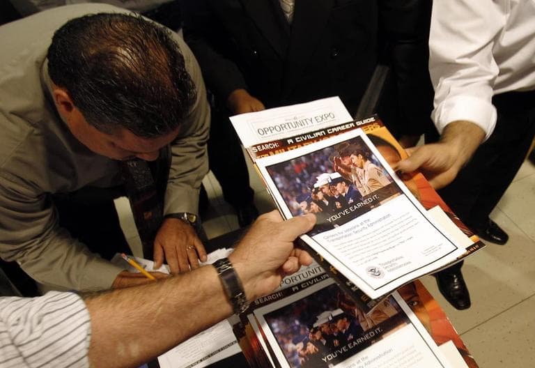 People receive information packets as they sign-in to attend the Opportunity Expo held by RecruitMilitary, Thursday, in Miami. (AP)