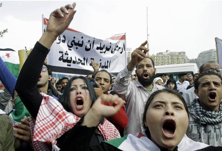 Syrian protesters shout anti-Syrian Preident Bashar Assad slogans during a protest in front of the Arab League headquarters in Cairo, Egypt, Saturday, Nov.12, 2011 where the League emergency session on Syria is to discuss the country's failure to end bloodshed caused by government crackdowns on civil protests. Protesters called the Arab League to suspend the country's membership. Arabic read " step out, we need to build civilian modern country" (AP)