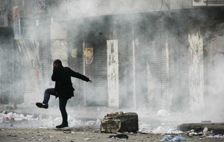 An Egyptian protester covers his face from tear gas during the clashes with Egyptian riot police, unseen, in Cairo, Egypt, Monday. (AP)