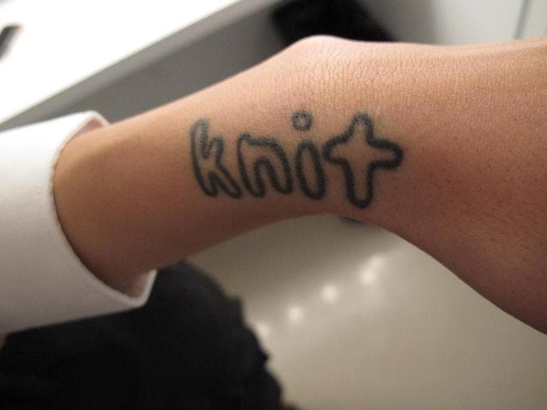 Fashion designer and knitter Lindsay Degen is a soldier in Liz Collin's army of knitters and sports this tattoo on her wrist. (Andrea Shea/WBUR)