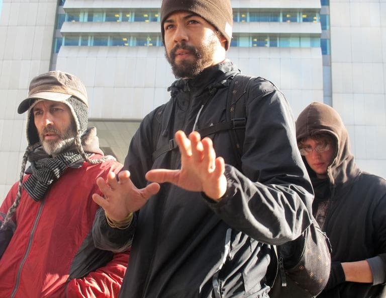 K. Eric Martin, center, and other demonstrators discuss possible eviction Wednesday. (Bianca Vazquez Toness/WBUR)