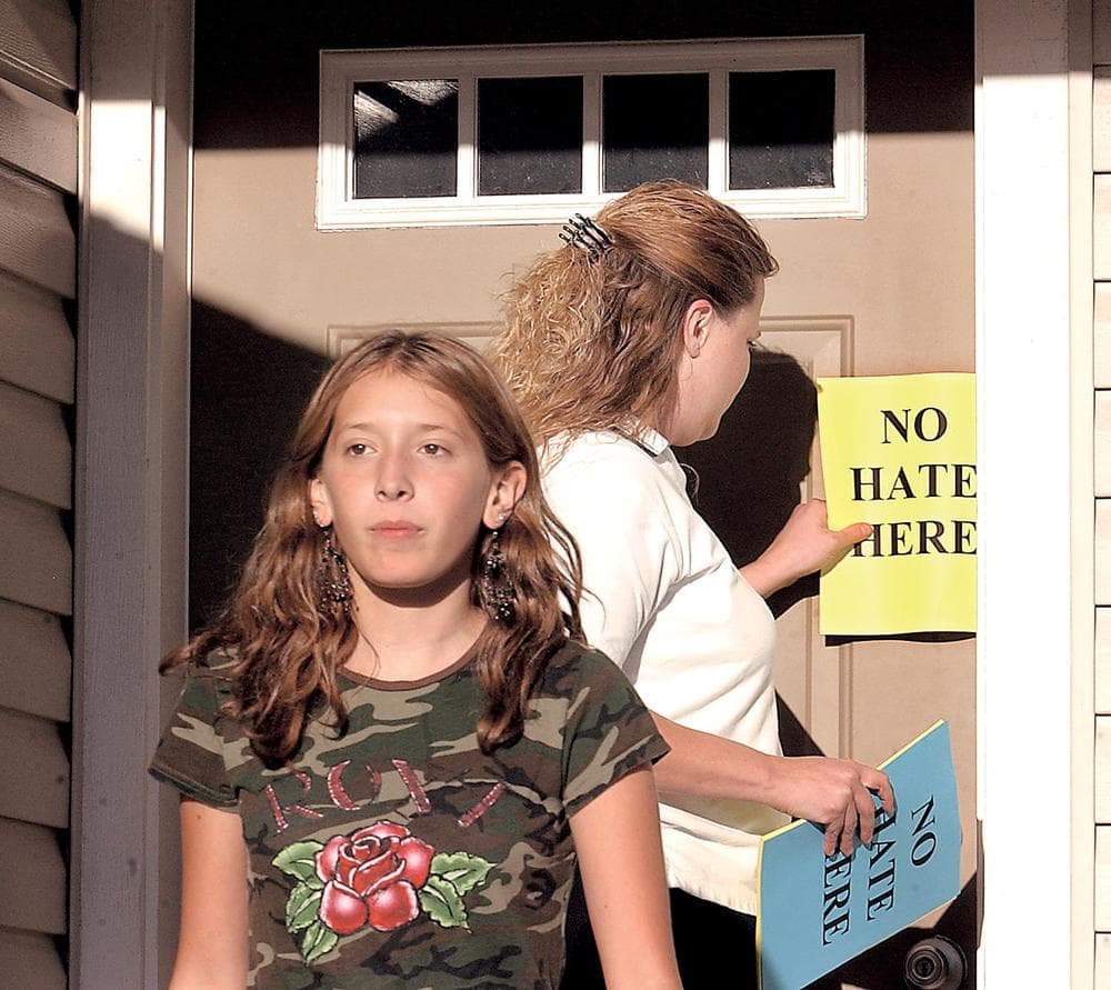 Jill Summers, right, and her daughter, leave a flier that says "No hate here" in 2006 on a neighbor's door, in Kalispell, Mont. The arrival of a white nationalist family of April Gaede has prompted neighbors to distribute the fliers. (AP)
