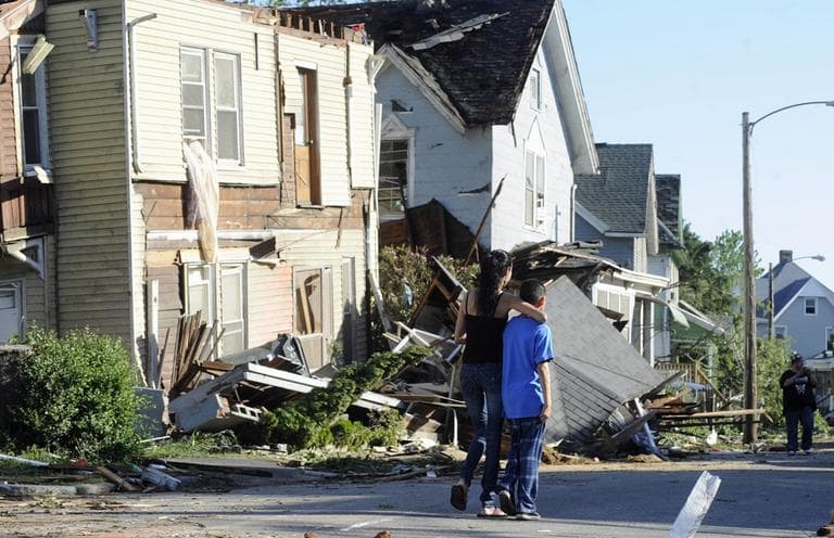 People walk past storm damage a day after a tornado in Springfield. (AP)