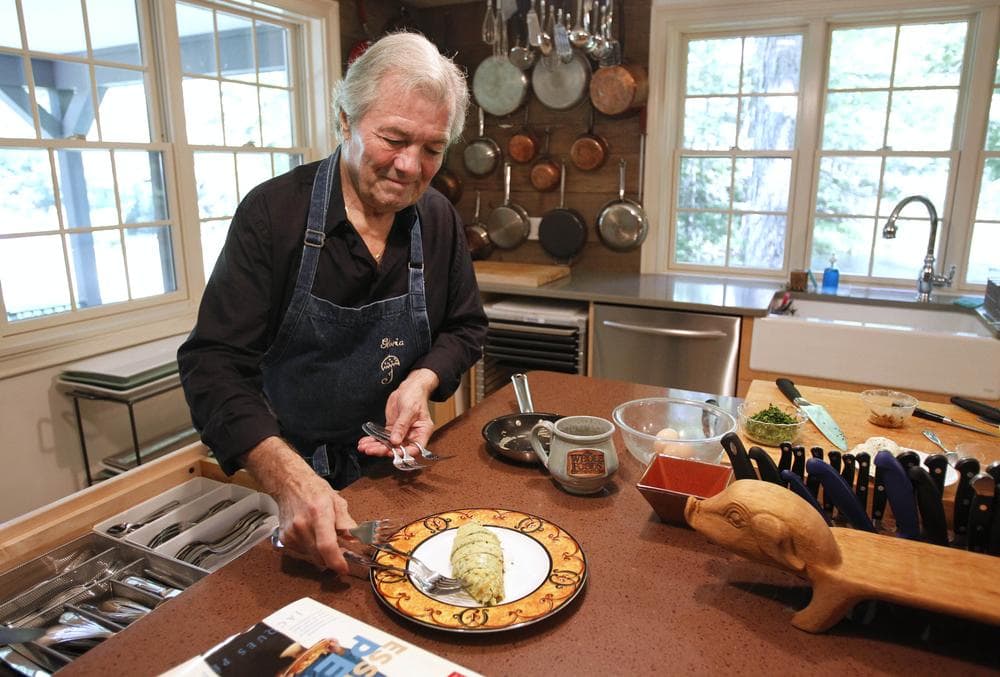 Chef Jacques Pepin places silverware on a plate with an omelette at his home in Madison, Conn. (AP)