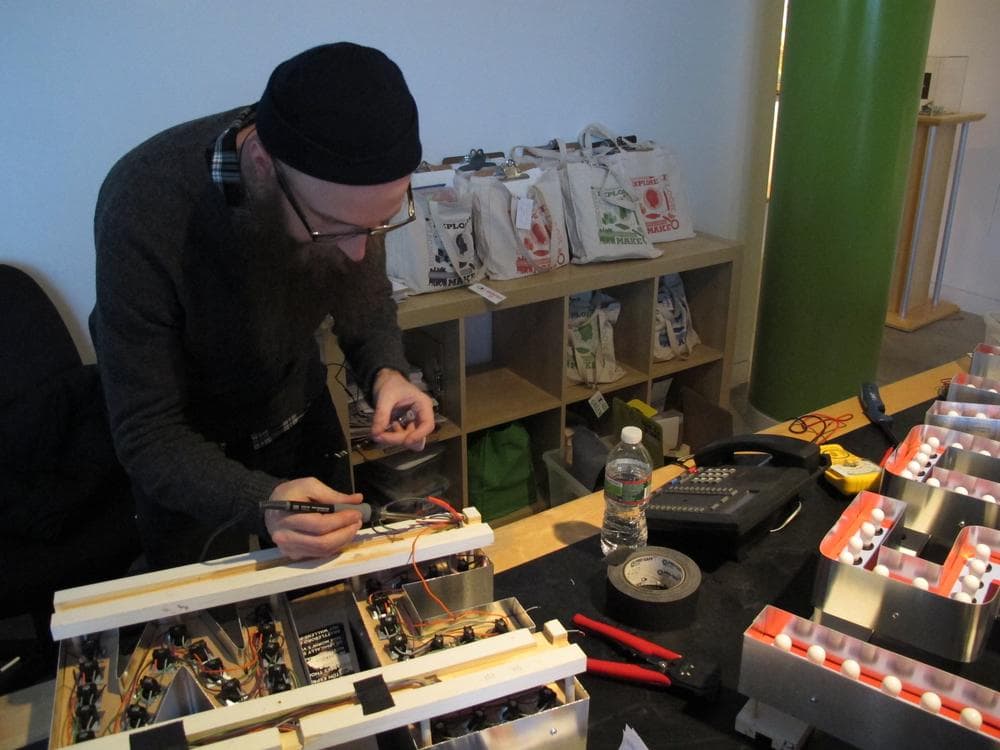 Jamaica Plain artist Steve Lambert prepares his piece for the Biennial. (Andrea Shea/WBUR)