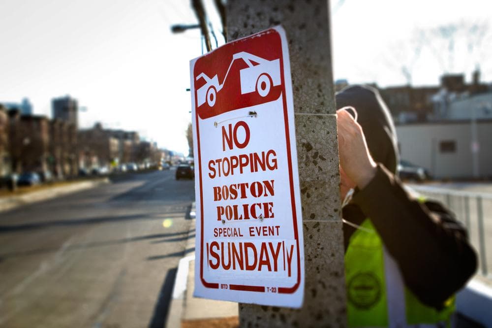 A Boston city worker hangs "No Stopping" signs Friday morning on Brighton Avenue in Allston in preparation for Super Bowl XLVI. (Jesse Costa/WBUR)