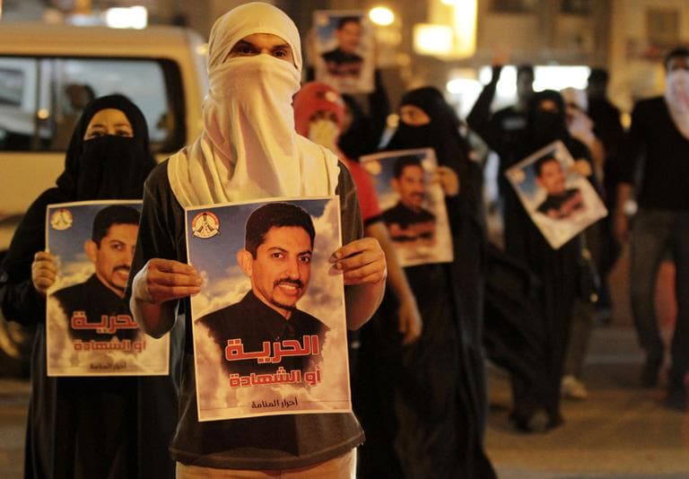 Bahraini anti-government protesters carry images of jailed hunger-striker Abdulhadi al-Khawaja that read "Freedom or martyrdom" during a demonstration Sunday outside the Interior Ministry in Manama, Bahrain. (AP)