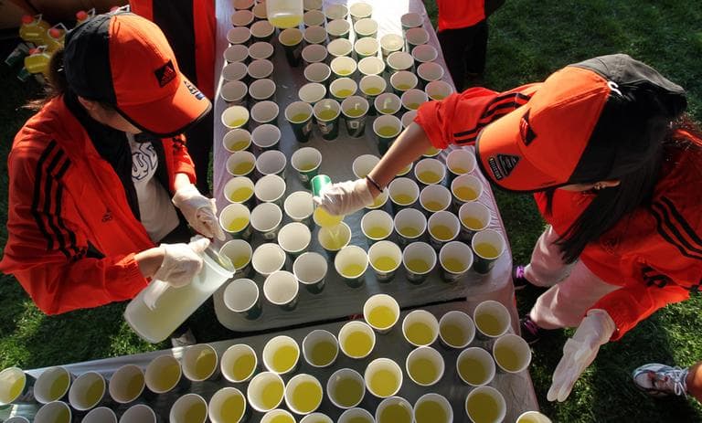 Volunteers fill cups at the athlete's village prior to the start of the 116th running of the Boston Marathon, in Hopkinton. (AP)