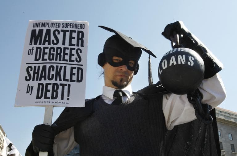 In this Oct. 6, 2011 photo, Gan Golan, of Los Angeles, dressed as the "Master of Degrees," holds a ball and chain representing his college loan debt, during Occupy DC activities in Washington. (AP)