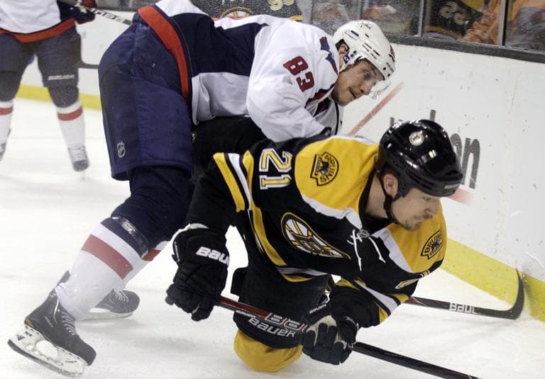 Washington Capitals center Jay Beagle (83) checks Boston Bruins defenseman Andrew Ference (21) as they compete along the boards for the puck during the first period of Game 7 of an NHL hockey Stanley Cup first-round playoff series, in Boston on Wednesday. (AP)