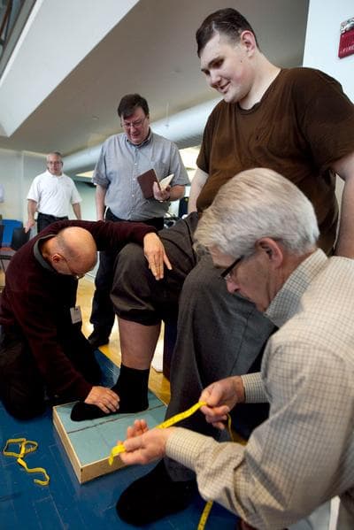 Igor Vovkovinskiy, currently the tallest man in the U.S. at 7-foot-8, has an imprint taken of his foot by technicians at Reebok headquarters, in Canton on Thursday. (AP)