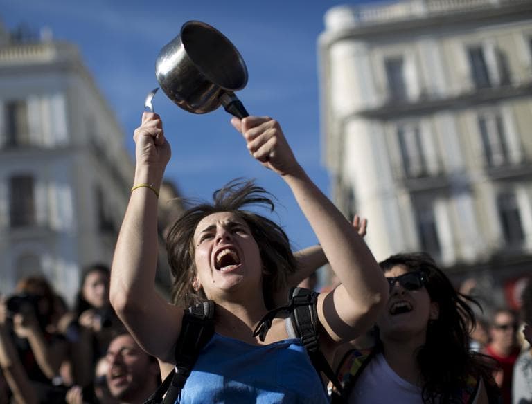 A demonstrator hit a pot during a protest to mark the anniversary of the "Indignados" movement in Sol square, Madrid, Spain, Tuesday May 15, 2012. Spaniards angered by increasingly grim economic prospects and unemployment hitting one out of every four citizens protested in droves in the nation's largest cities, marking the one-year anniversary of a spontaneous movement that inspired similar anti-authority demonstrations across the planet. (AP)