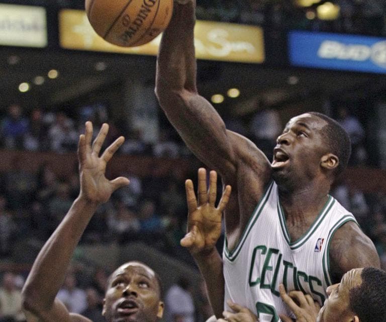 Brandon Bass reaches for a rebound against Philadelphia 76ers defenders Elton Brand and Evan Turner during the first quarter of Game 5 in Boston, Monday. (AP)