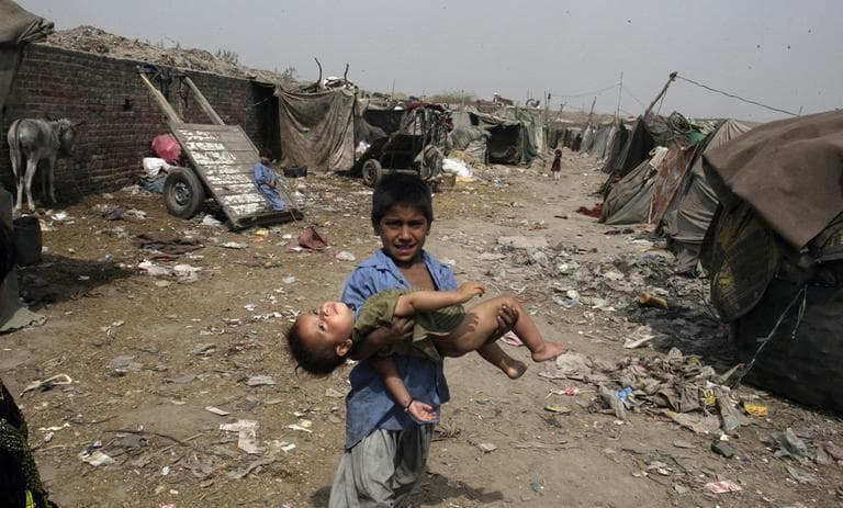 A Pakistani boy carries a child for to recieve polio drops in the suburbs of Lahore, Pakistan. (AP)