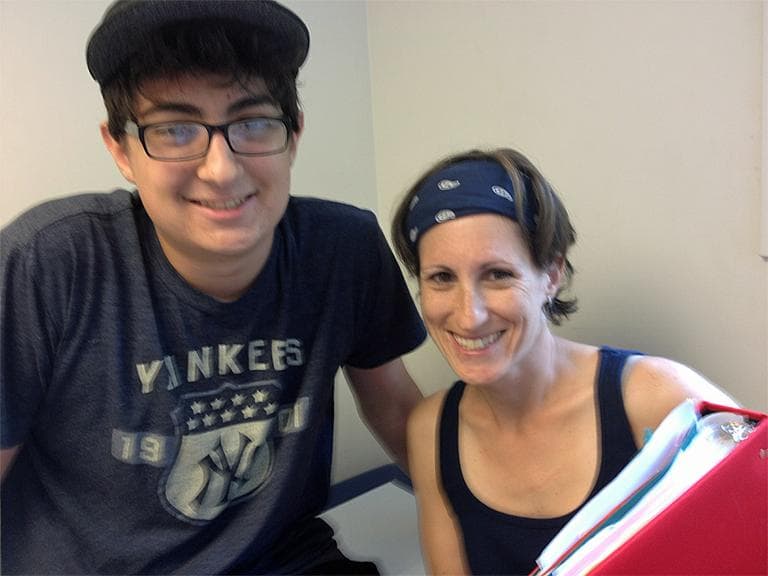 Zachary Tenreiro with his mother Maria Tenreiro and her red "boys medical" binder. (Martha Bebinger/WBUR)