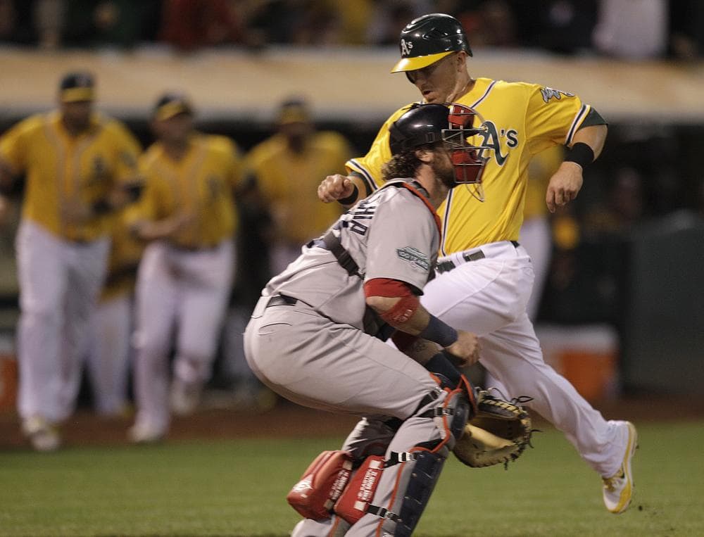 Oakland's Cliff Pennington scores the game winning run hit off  Red Sox catcher Jarrod Saltalamacchia last night in Oakland. Pennington scored on a sacrifice fly hit by Coco Crisp. (AP Photo)
