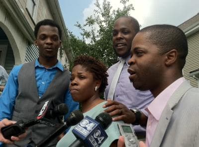 The Rev. Michel Louis' four children celebrate his release in Dorchester on Monday. (Delores Handy/WBUR)