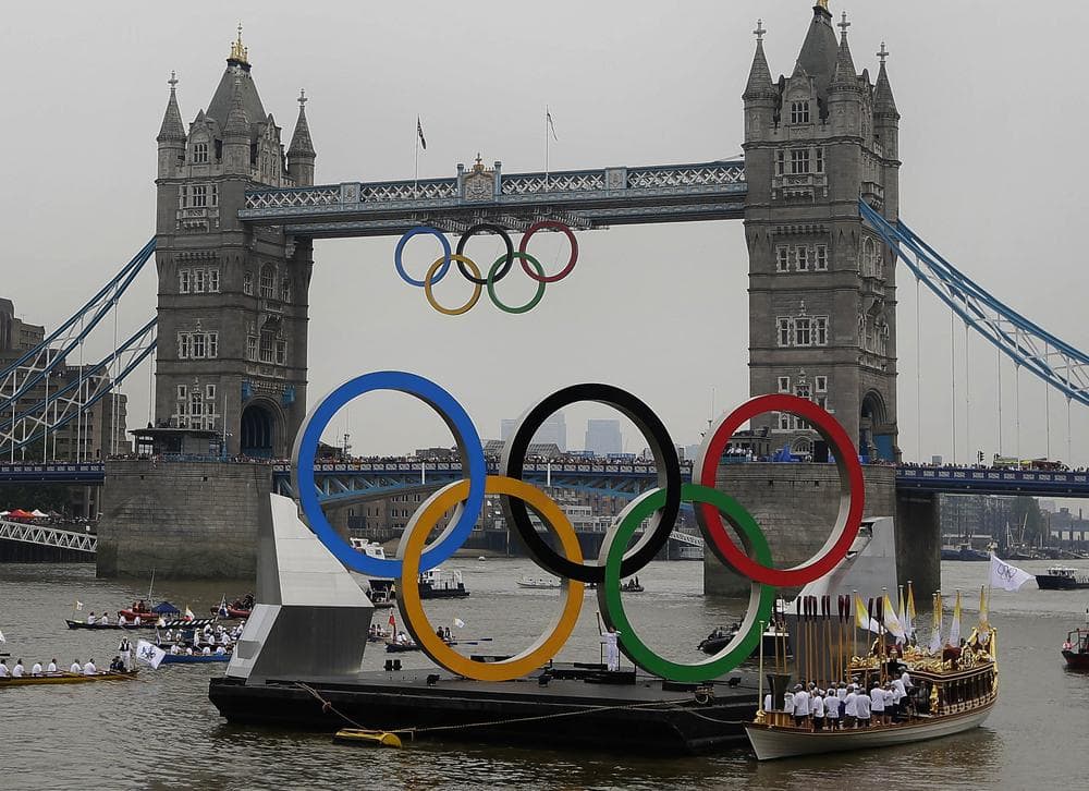 The royal barge Gloriana carries the Olympic flame along the river Thames on the final day of the Torch Relay, Friday, in London. (AP)
