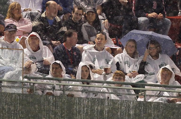 Fans use umbrellas and plastic ponchos for protection from the rain in the first inning of the game between the Detroit Tigers and the Boston Red Sox at Fenway Park on Tuesday. (AP Photo/Steven Senne)