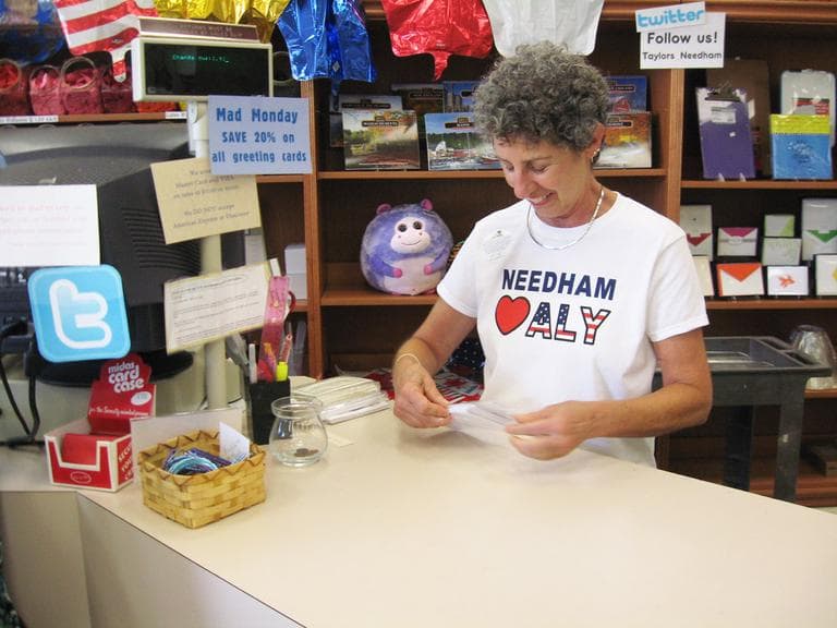 Toby Sandler, an employee at Taylor's Stationery, wearing one of the store's t-shirts supporting Aly Raisman (Lynn Jolicoeur for WBUR)