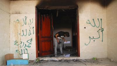 A man looks at documents at the U.S. Consulate in Benghazi, Libya, on Wednesday, after an attack that killed four Americans, including Ambassador Chris Stevens. The graffiti reads, "no God but God," " God is great," and "Muhammad is the Prophet." (AP)