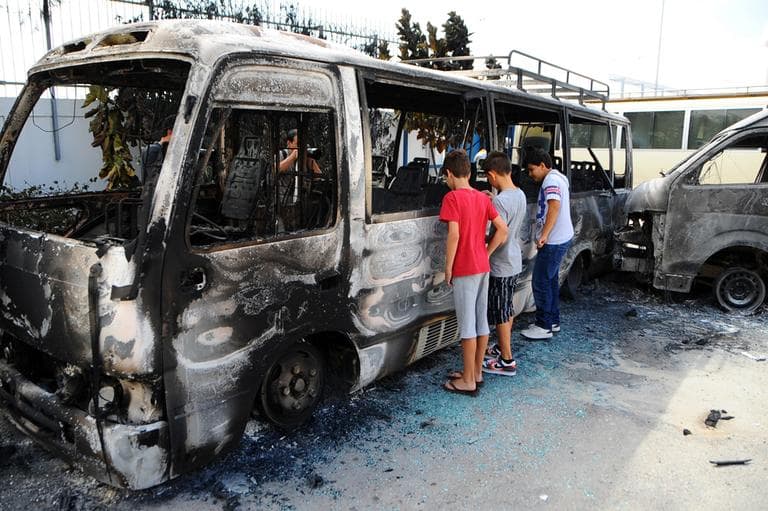 Children look at a burned bus at the American school adjacent to the U.S. embassy compound in Tunis, Tunisia, Saturday, Sept. 15, 2012 , a day after several thousand demonstrators angry over a film that insults the Prophet Muhammad stormed the compound. (AP)