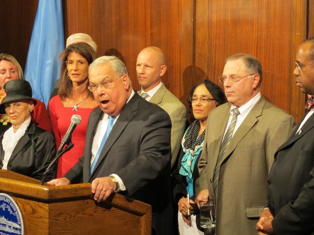 Mayor Thomas Menino speaks at a press conference announcing the tentative labor agreement. Carol Johnson, superintendent of Boston Public Schools, stands behind him. Richard Stutman, president of the Boston Teachers Union, stands on Johnson's left. (Monica Brady-Myerov/WBUR)
