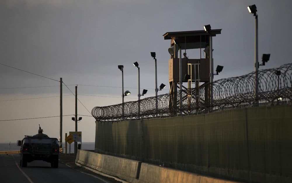 A U.S. trooper stands in the turret of a vehicle with a machine gun, left, as a guard looks out from a tower, in this 2010 photo of Guantanamo Bay U.S. Naval Base in Cuba. (Brennan Linsley/AP)