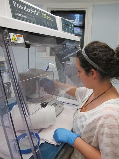 A worker weighs an ingredient at J.E. Pierce Apothecary, a compounding pharmacy in Brookline. (Curt Nickisch/WBUR)