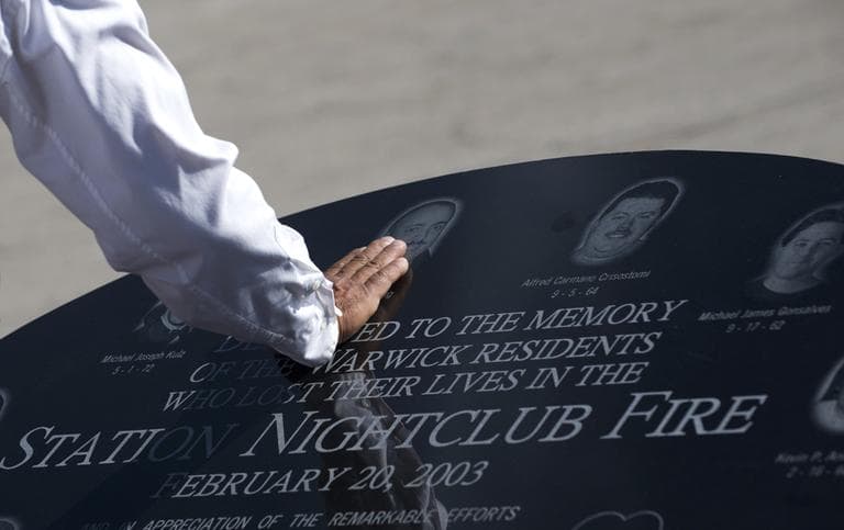 Jody King touches the image of his brother Tracy King, following a ceremony, in Warwick on Saturday held to unveil a memorial stone that honors victims of the 2003 Station Nightclub Fire.  (Gretchen Ertl/AP)