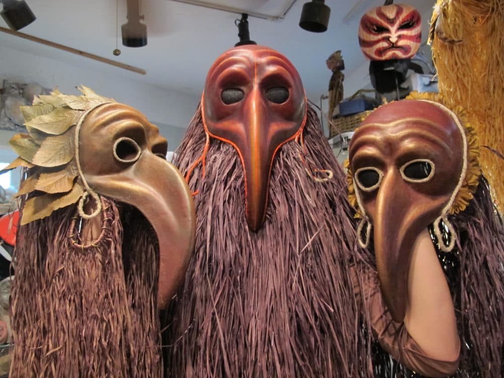 Studio assistant Anya Malkina holds up some masks. (Andrea Shea/WBUR)