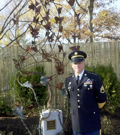 Staff Sgt. William Kleinedler and his sculpture, "Integro," in the new Fisher House Healing Garden at the VA Medical Center in West Roxbury (Lynn Jolicoeur/WBUR)