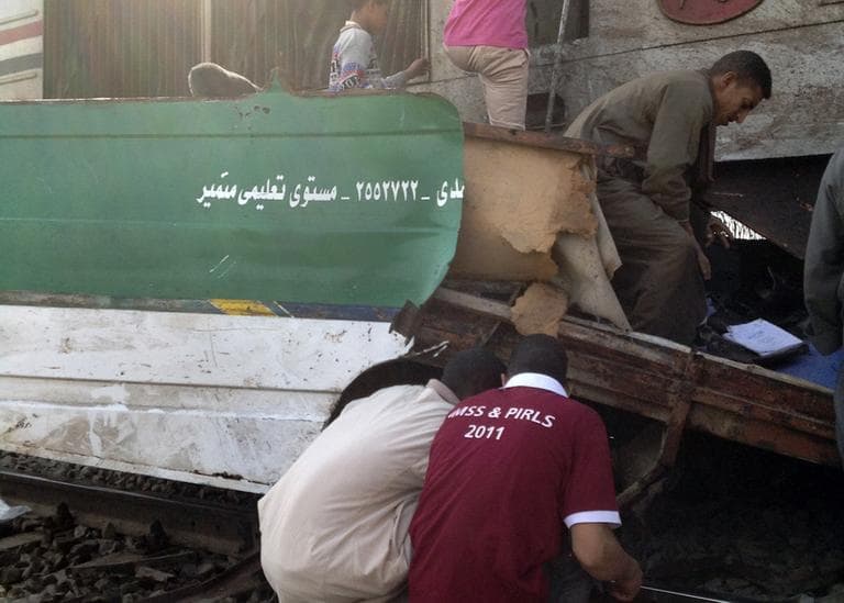 Egyptians inspect the wreckage after a speeding train crashed into a bus carrying children to their kindergarten in southern Egypt on Saturday, killing dozens. (Mamdouh Thabet/AP)