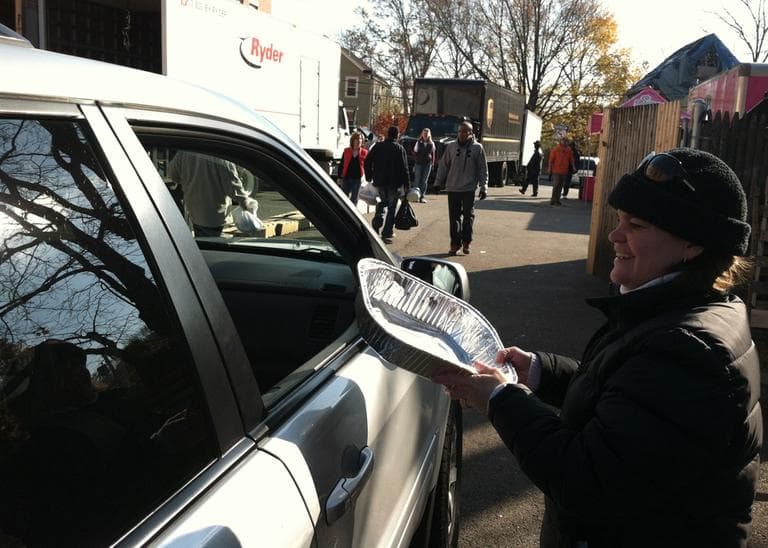 A volunteer distributes supplies as part of the United Way's Thanksgiving Project in Dorchester Saturday. (Jack Lepiarz/WBUR)