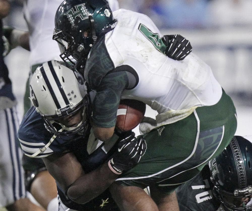 Brigham Young's Ezekiel "Ziggy" Ansah tackles a Hawaii player during a September game in Utah. Ansah grew up in Ghana, where he played soccer and basketball, and walked onto the BYU football team after two years running track for the school. (/Rick Bowmer/AP)