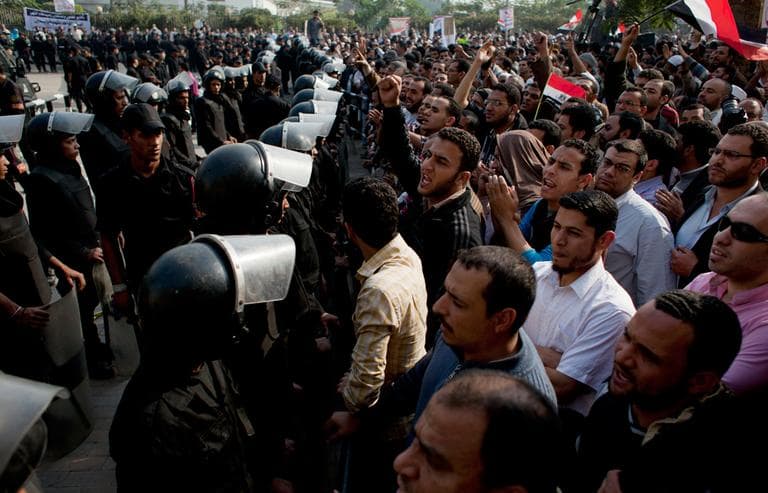 Supporters of Egyptian President Mohammed Morsi chant slogans as riot police, left, stand guard in front of the entrance of Egypt’s top court, in Cairo, Egypt on Sunday. (Nasser Nasser/AP)
