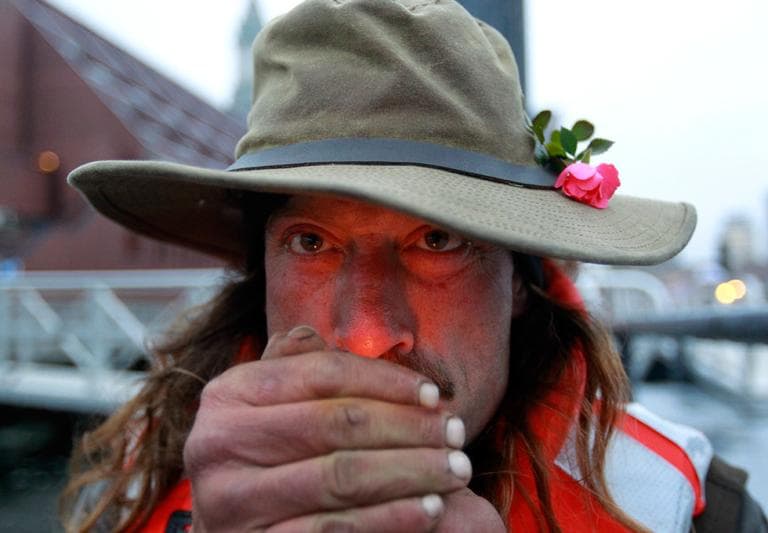 Michael Richard Smith lights a cigarette on a wharf in Boston Harbor Tuesday. (Steven Senne/AP)