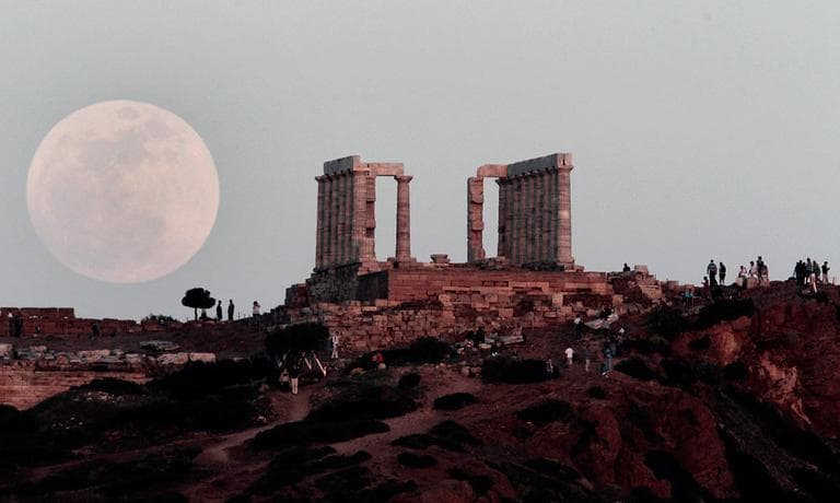A full moon rises behind the Temple of Poseidon in Cape Sounion, south east of Athens, Greece, while tourists watch, on Saturday, May 5, 2012. Saturday's event is a "supermoon," the closest and therefore the biggest and brightest full moon of the year. (AP Photo/Dimitri Messinis)