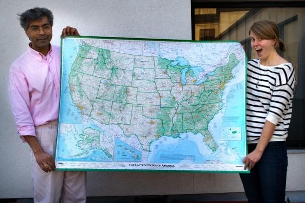 Here & Now producers Hitesh Hathi (left) and Jill Ryan hold Dave Imus' massive map of the United States. (Jesse Costa/Here & Now)