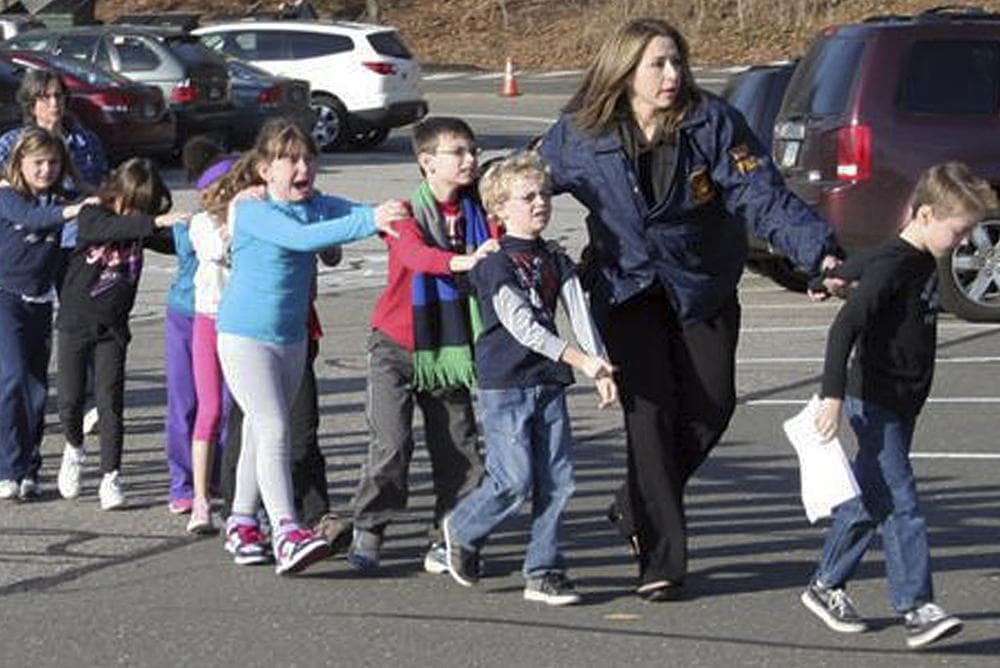 In this photo provided by the Newtown Bee, Connecticut State Police lead children from the Sandy Hook Elementary School in Newtown, Conn., following a reported shooting there Friday, Dec. 14, 2012. (AP Photo/Newtown Bee, Shannon Hicks) MANDATORY CREDIT