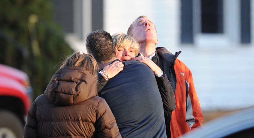 Unidentified people embrace on December 14, 2012 at the aftermath of a school shooting at a Connecticut elementary school. At least 27 people, including 18 children, were killed on Friday when at least one shooter opened fire at an elementary school in Newtown, Connecticut, CBS News reported, citing unnamed officials. (Don Emmert/AFP via Getty Images)