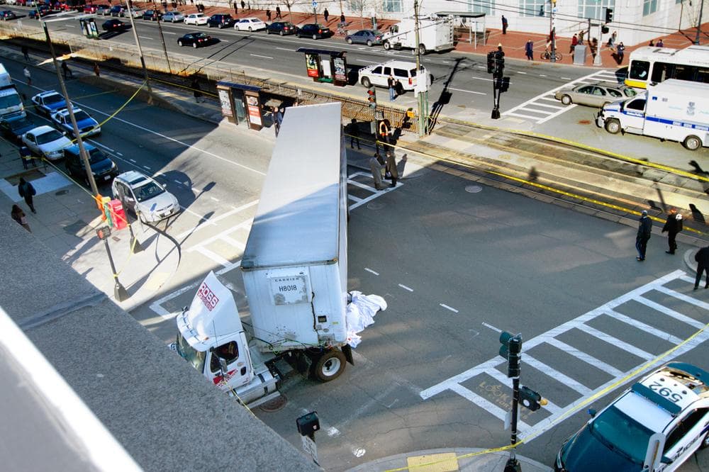 A sheet covers the body of a 23-year-old bicyclist killed at the intersection of Commonwealth Avenue and St. Paul Street Thursday morning. (Jesse Costa/WBUR)