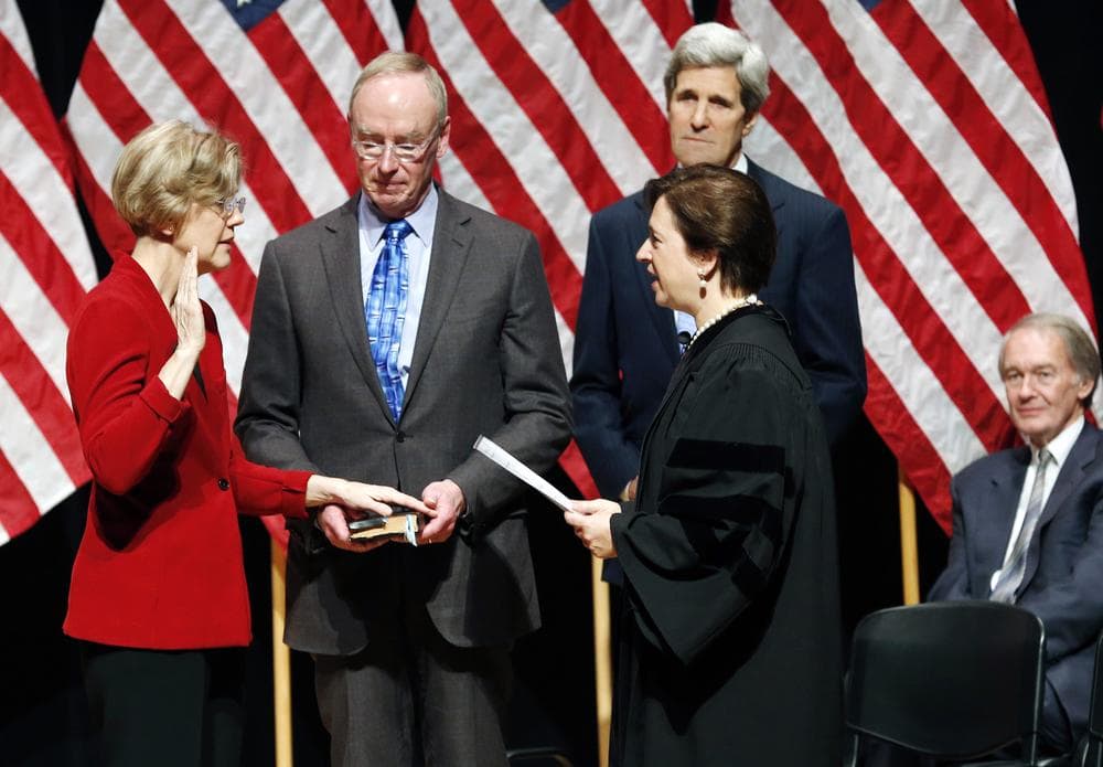Supreme Court Justice Elena Kagan administers the oath of office to Sen. Elizabeth Warren as Warren's husband, Bruce Mann, holds a bible during a re-enactment of Warren's Senate swearing-in ceremony at Roxbury Community College Saturday. (Michael Dwyer/AP)