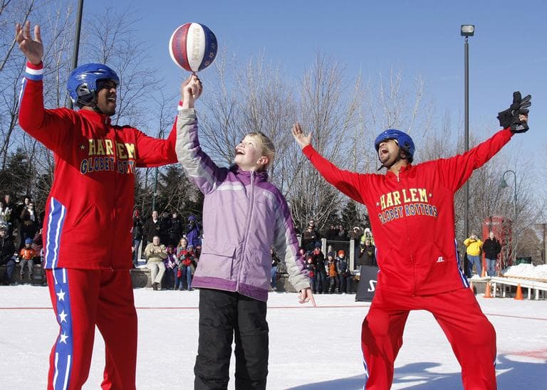 Emilee Bogda, 10,  learns some tricks from Globetrotters Scooter Christensen (l) and Handles Franklin. (William Pugliano/Harlem Globetrotters/AP)