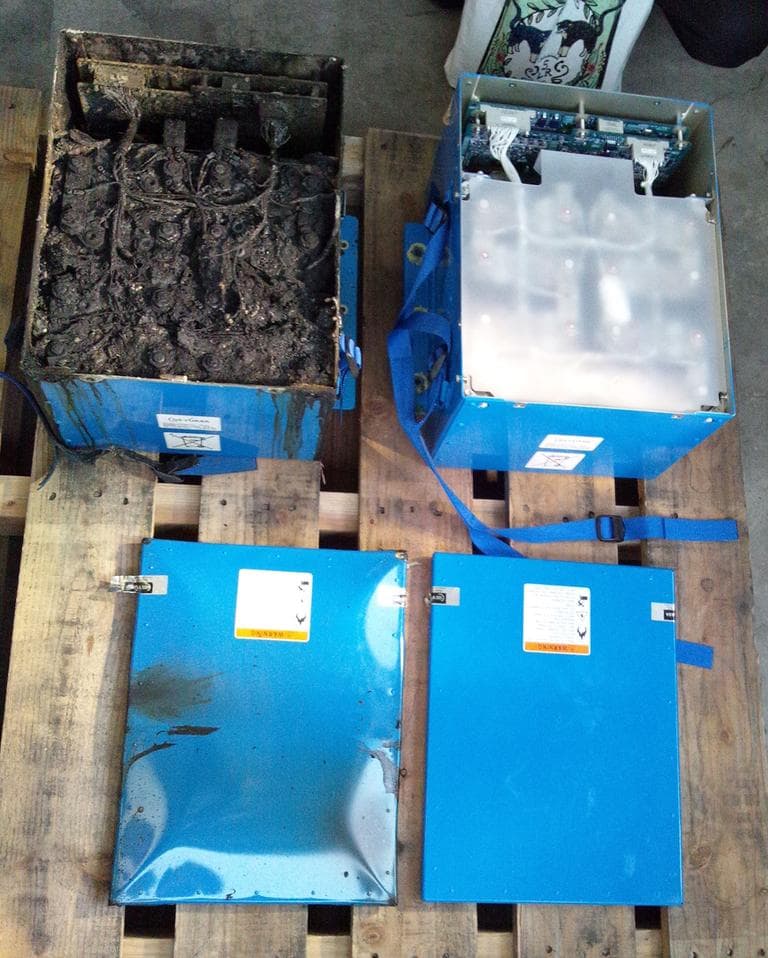 This photo provided on Thursday by the Japan Transport Safety Board shows the distorted main lithium-ion battery and its lid, left, of the All Nippon Airways' Boeing 787, which made an emergency landing on Wednesday at Takamatsu airport in western Japan. At right are the model in normal condition. (Japan Transport Safety Board/AP)